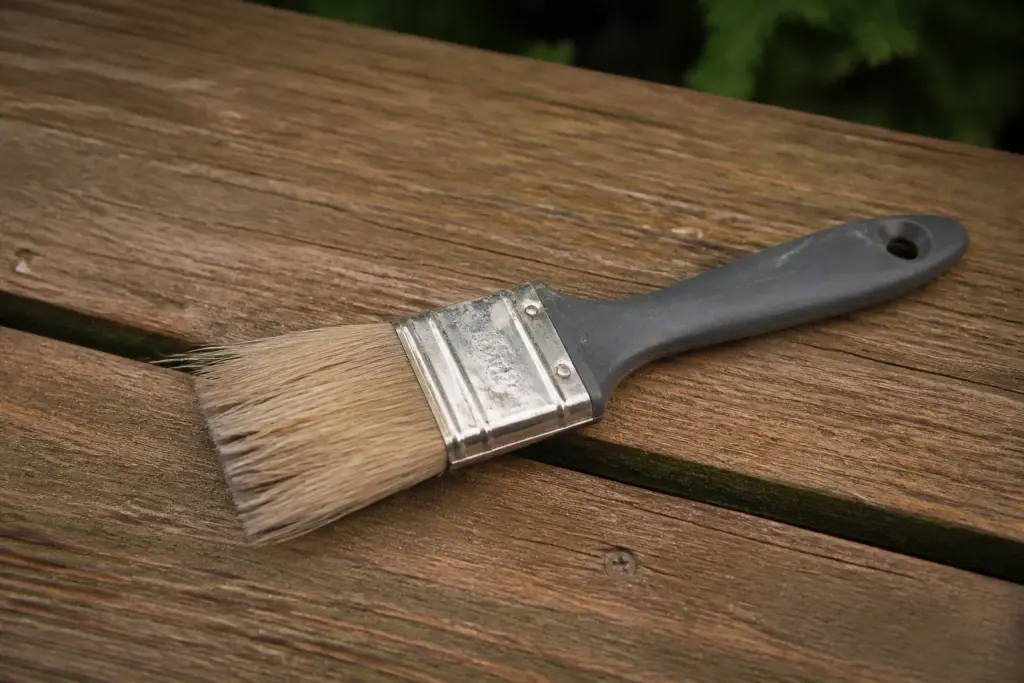 Pinceau posé sur une planche de terrasse en bois