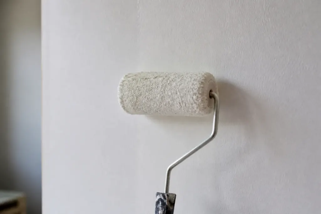 Rouleau de colle applique sur un mur blanc